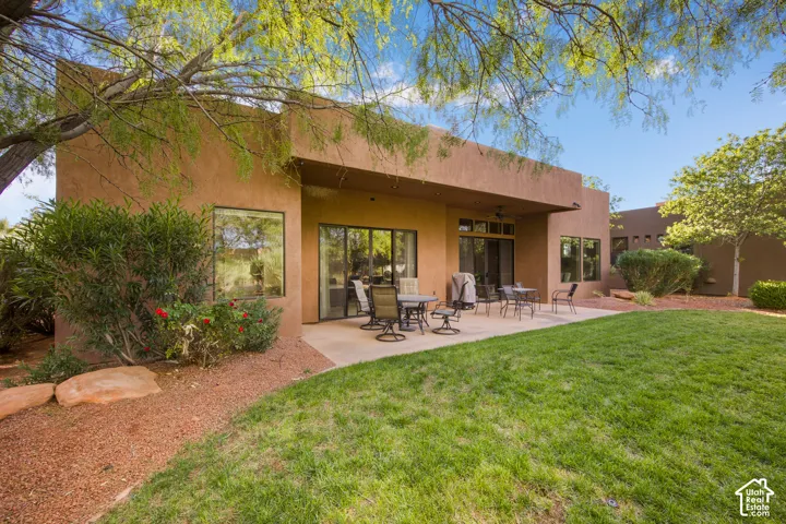 Terracotta stucco exterior with expansive rear patio featuring multiple French doors and direct access to the backyard