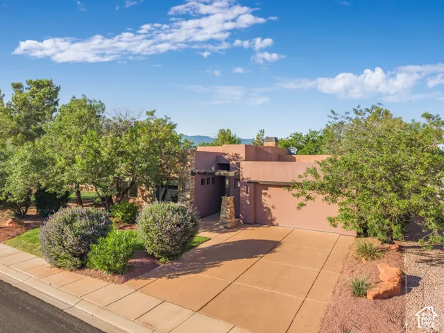 Southwestern-style architecture featuring a stucco exterior, concrete driveway, and integrated garage