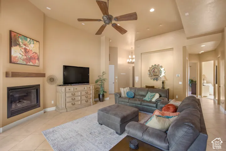 Living area featuring a fireplace with a wood mantle, a ceiling fan, tiled flooring, and recessed lighting