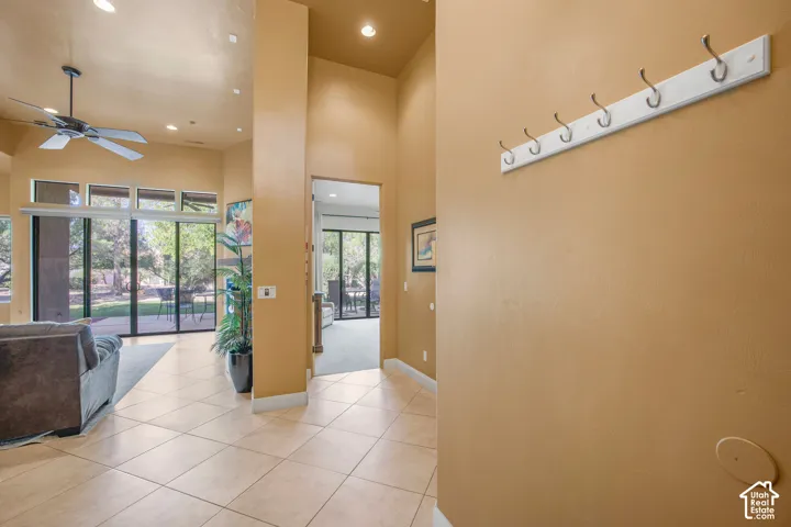 Tile flooring, recessed lighting, ceiling fan, and multiple large glass sliding doors