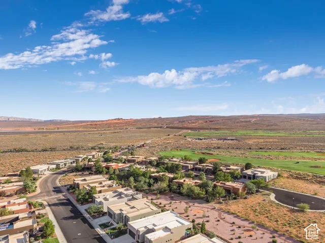 Community featuring modern architecture, extensive golf course frontage, desert landscaping, and paved roadways