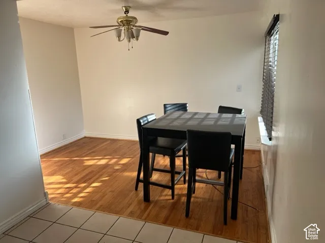 Wood-finish flooring, ceiling fan with integrated lighting, and horizontal window blinds