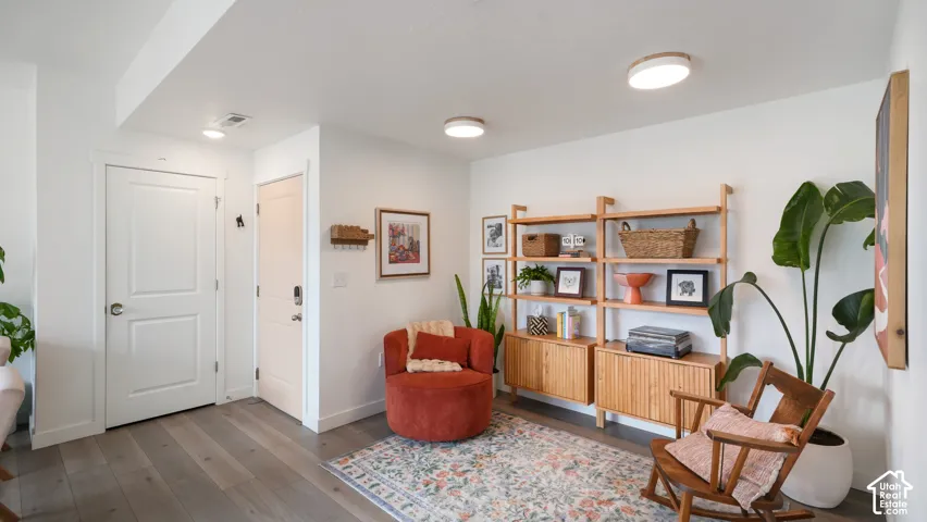 Interior space featuring wood-finish flooring, white walls, two flush-mount ceiling light fixtures, and two solid-core interior doors