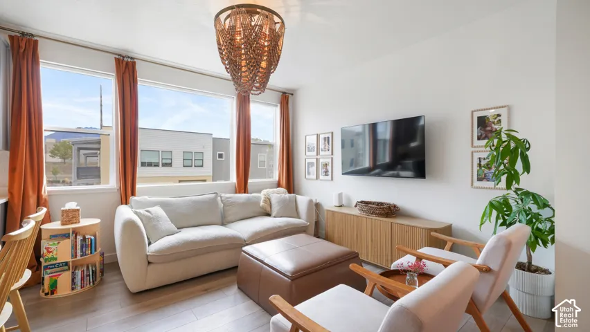 Living space featuring large multi-panel windows, wood-finish flooring, and a decorative pendant light fixture