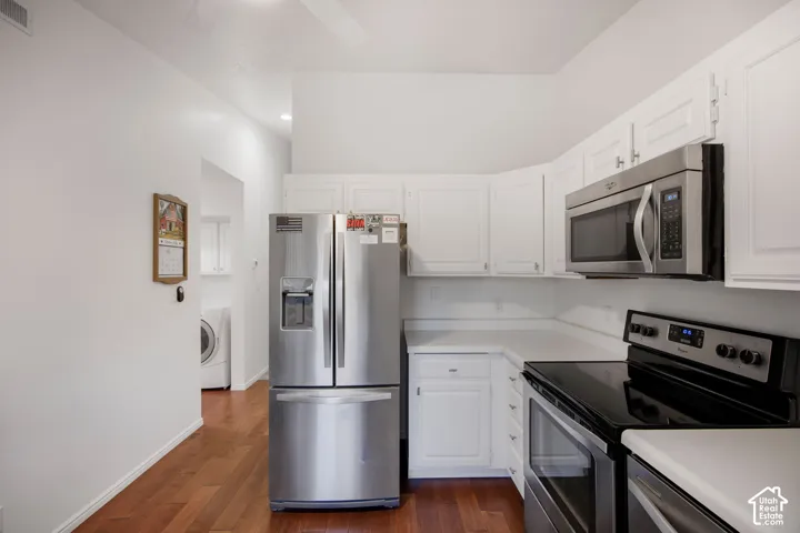 Kitchen featuring white shaker-style cabinetry, wood-finish flooring, and stainless steel appliances including a French door refrigerator and over-the-range microwave