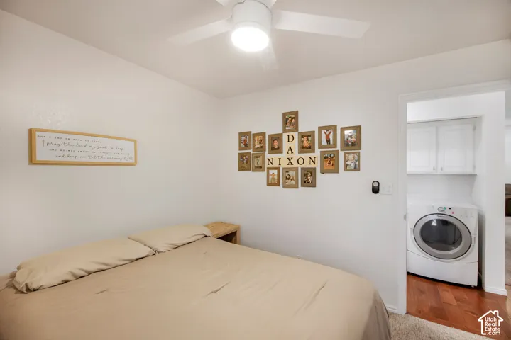 Ceiling-mounted fan with integrated lighting and wall-mounted laundry area featuring white cabinetry