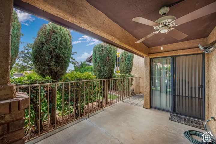 Covered patio featuring concrete flooring, a ceiling-mounted fan, metal railing, and sliding glass entry doors