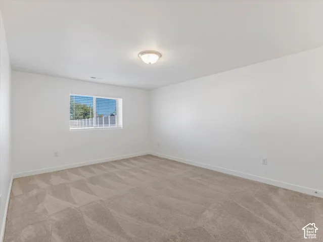 Bedroom #6 with neutral carpeting, flush mount lighting, window featuring horizontal blinds and a walk-in closet
