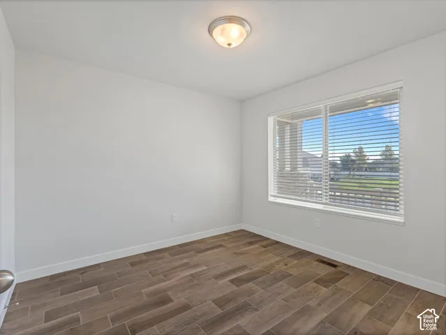 Bedroom #2 with wood-finish tile flooring, flush-mount ceiling lighting, and a large window