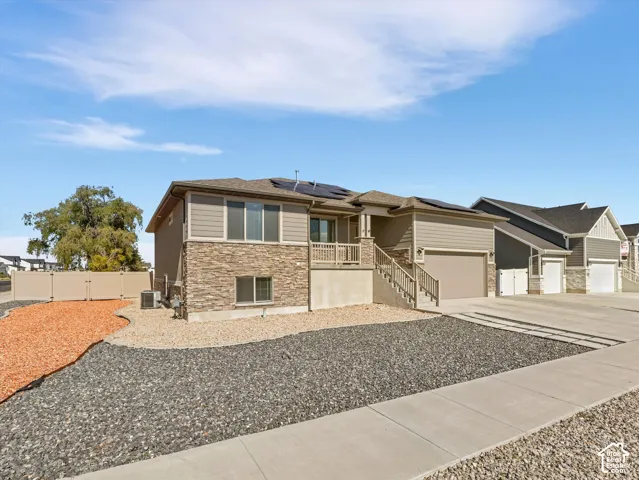 Exterior featuring a stone lower facade, horizontal siding, installed solar panels and zeroscape yard