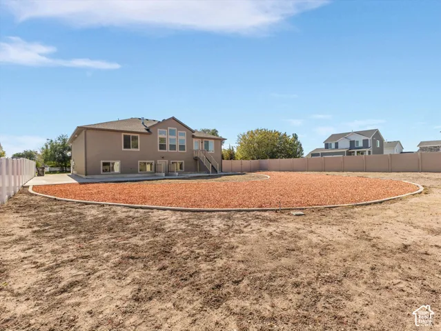 Backyard featuring a concrete patio, defined gravel landscaping area, and privacy fencing