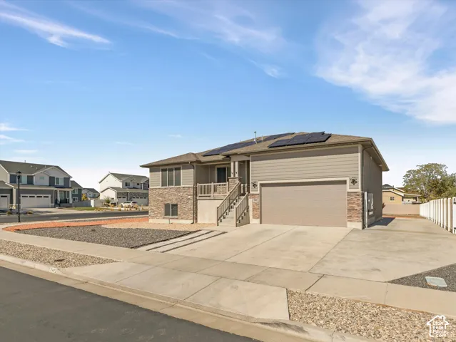 Exterior featuring a stone lower facade, horizontal siding, RV parking and installed solar panels