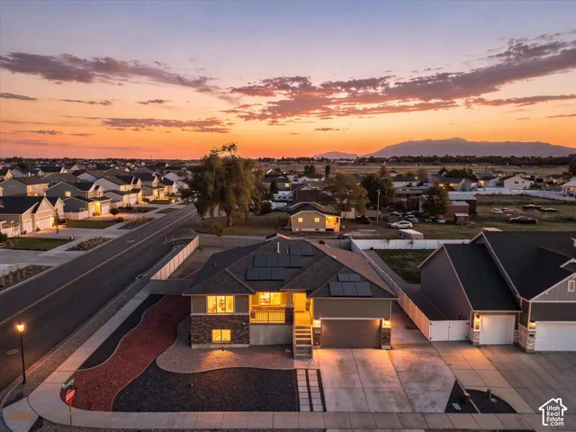Home featuring a stone and siding exterior, integrated solar panels, and low-maintenance zeroscaped landscaping