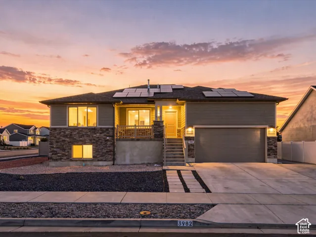 Exterior featuring a stone lower facade, horizontal siding and installed solar panels
