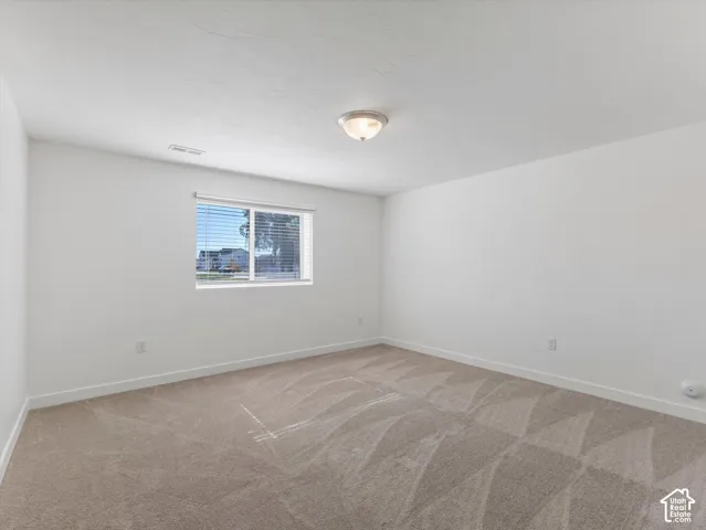 Bedroom #5 featuring neutral carpeting, window with horizontal blinds, walk-in closet and flush-mount lighting