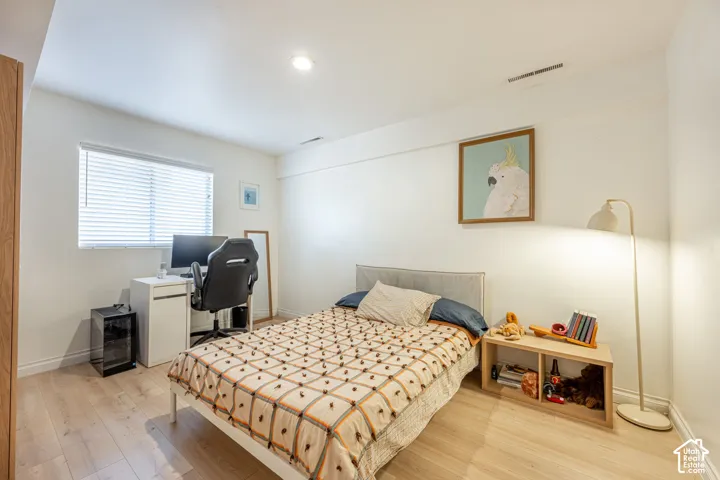 Interior space featuring wood-finish flooring, recessed lighting, and a window with horizontal blinds