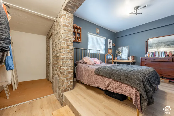 Exposed brick architectural feature, multi-level wood-finish flooring, and recessed ceiling lighting