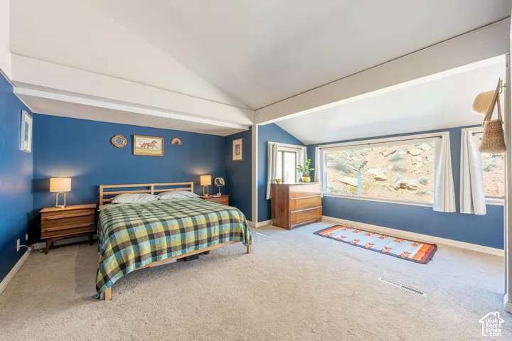 Primary Bedroom Vaulted ceilings, expansive windows, and wall-to-wall carpeting