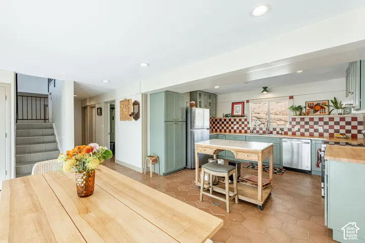 Kitchen featuring sage green cabinetry, a checkerboard tile backsplash, hexagonal tile flooring, and recessed lighting