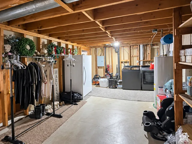 Unfinished lower level featuring exposed wood ceiling joists, concrete flooring, built-in wooden shelving, and washer and dryer utility hookups