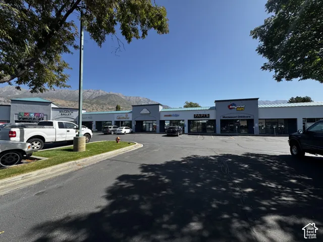 Commercial center featuring storefronts with metal roofing and mountain backdrop