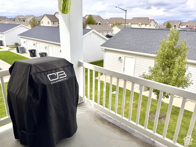 Covered balcony featuring white railing and concrete flooring