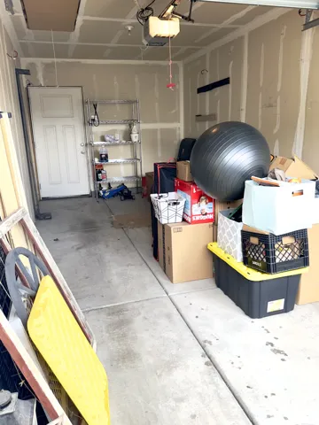 Garage featuring a concrete floor, motorized overhead door opener, and a paneled pedestrian door