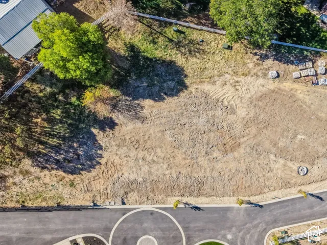 Graded parcel with paved road frontage, defined curb, and existing utility access