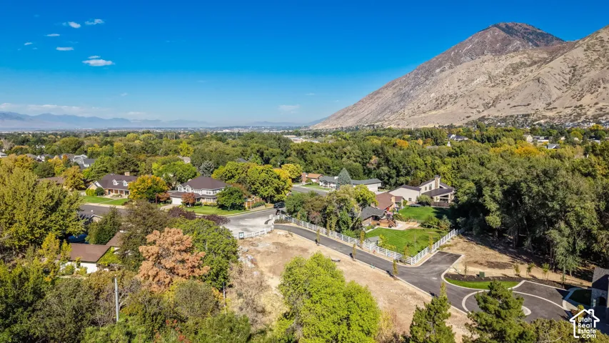 Expansive mountain backdrop, established neighborhood with mature trees, paved roads, and available land plots