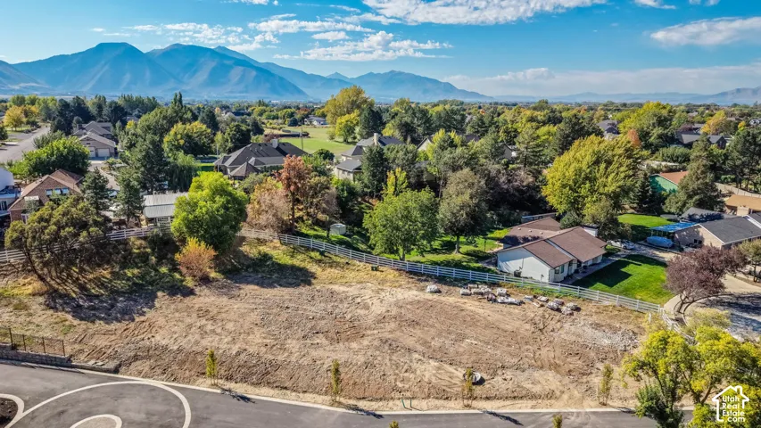 Cleared building lot with surrounding mature trees and mountain backdrop