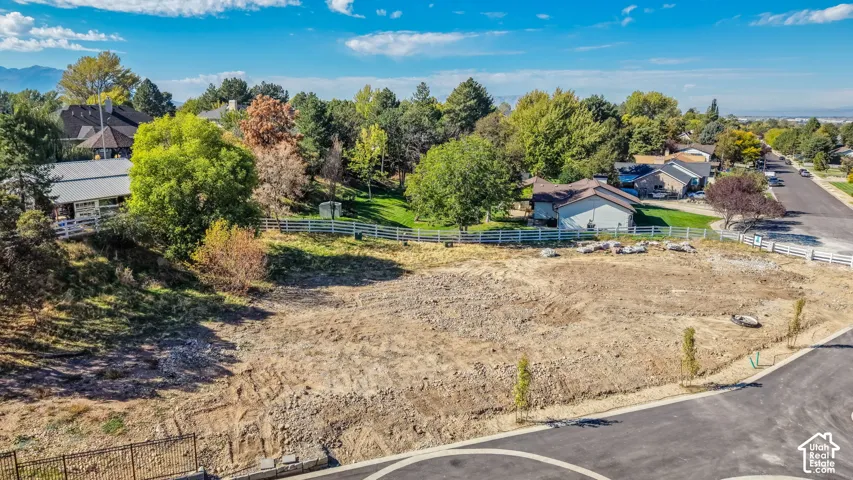 Level building lot featuring a paved road, curb, and gutter