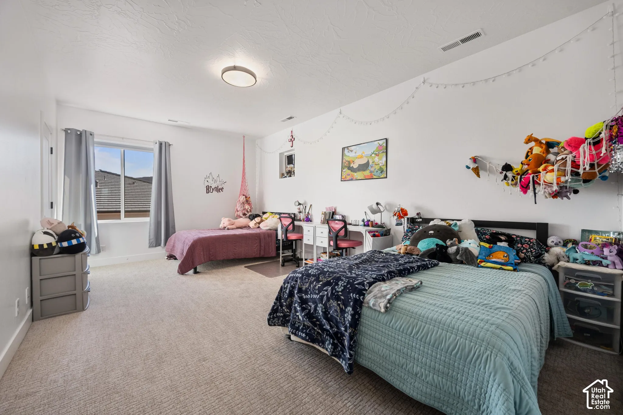 Spacious room featuring neutral carpeting, a large window, a flush-mount ceiling light fixture, and textured ceilings