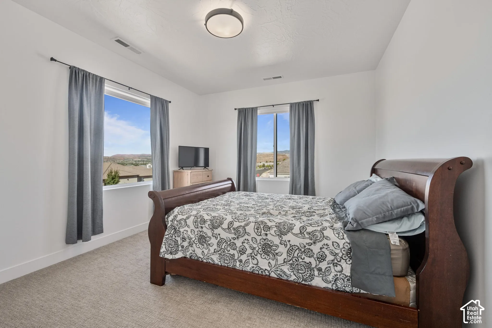 Neutral-toned carpet, recessed ceiling light, and dual windows with natural light