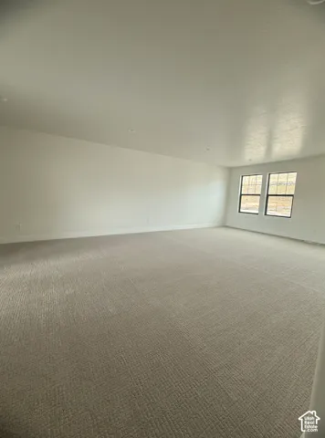 Neutral-toned wall-to-wall carpeting, recessed ceiling lighting, and double-paned windows with black frames