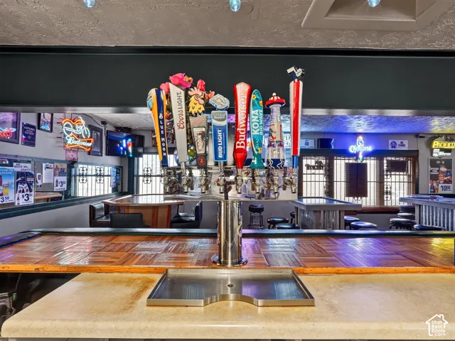 Custom bar area featuring a multi-tap draft system, stainless steel drip tray, tiled countertop surface, and built-in mirrored wall