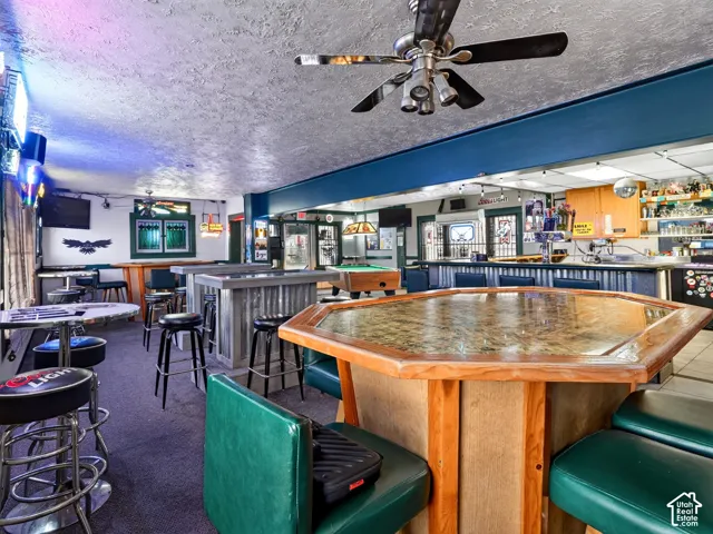 Custom wet bar featuring corrugated metal facing, solid wood trim, and octagonal tabletop with stone-finish surface