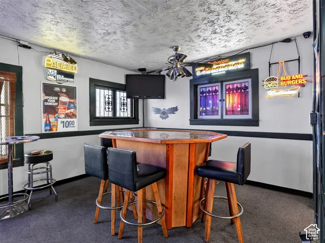 Built-in wooden hexagonal bar with a composite countertop and integrated ceiling fan