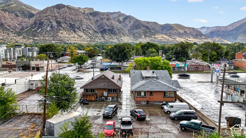 Aerial perspective showcasing brick-exterior buildings, expansive surface parking, and prominent mountain backdrop