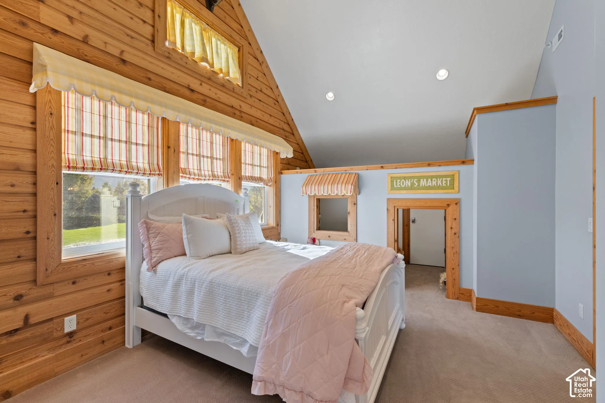 Vaulted ceiling featuring recessed lighting, horizontal wood-plank wall paneling, and an interior wood-trimmed pass-through opening