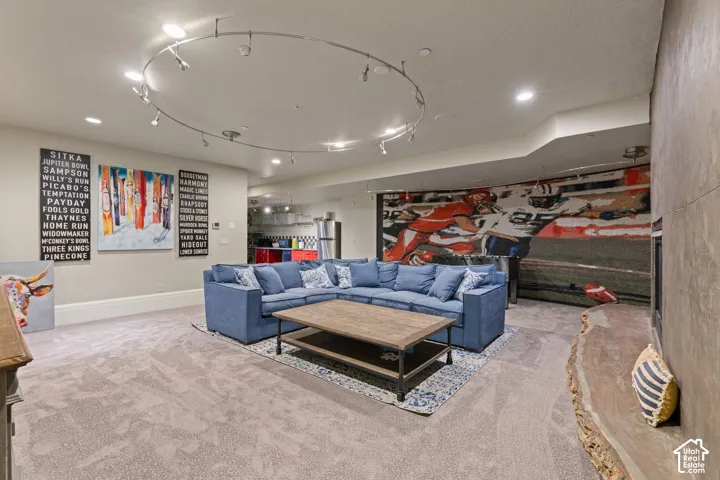 Circular track lighting, stone-finish fireplace surround, and custom live-edge wood hearth