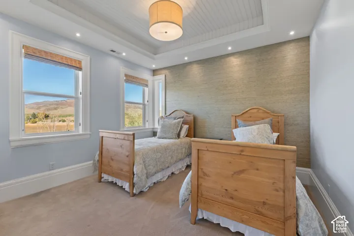Tray ceiling with beadboard detailing, recessed lighting, textured wall finish, and windows showcasing a mountain backdrop