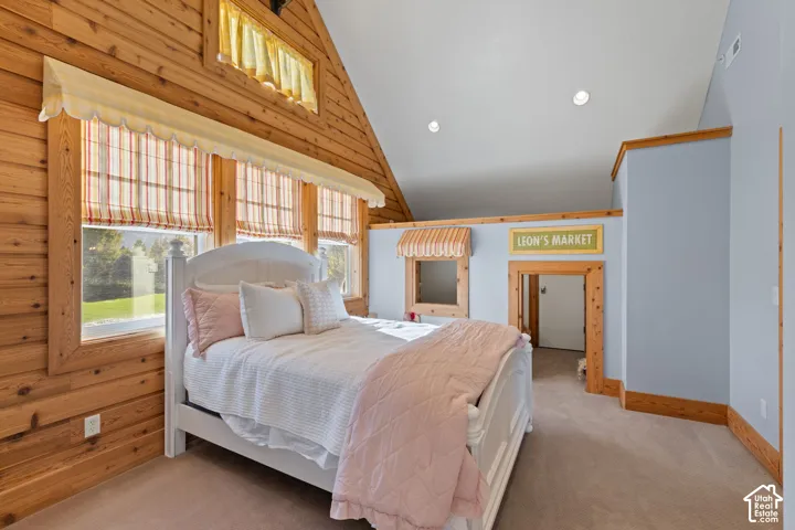 Vaulted ceiling featuring recessed lighting, horizontal wood-plank wall paneling, and an interior wood-trimmed pass-through opening