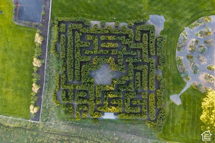 Expansive grounds featuring a mature hedge maze, manicured lawn areas, gravel paths, and ornamental landscaping