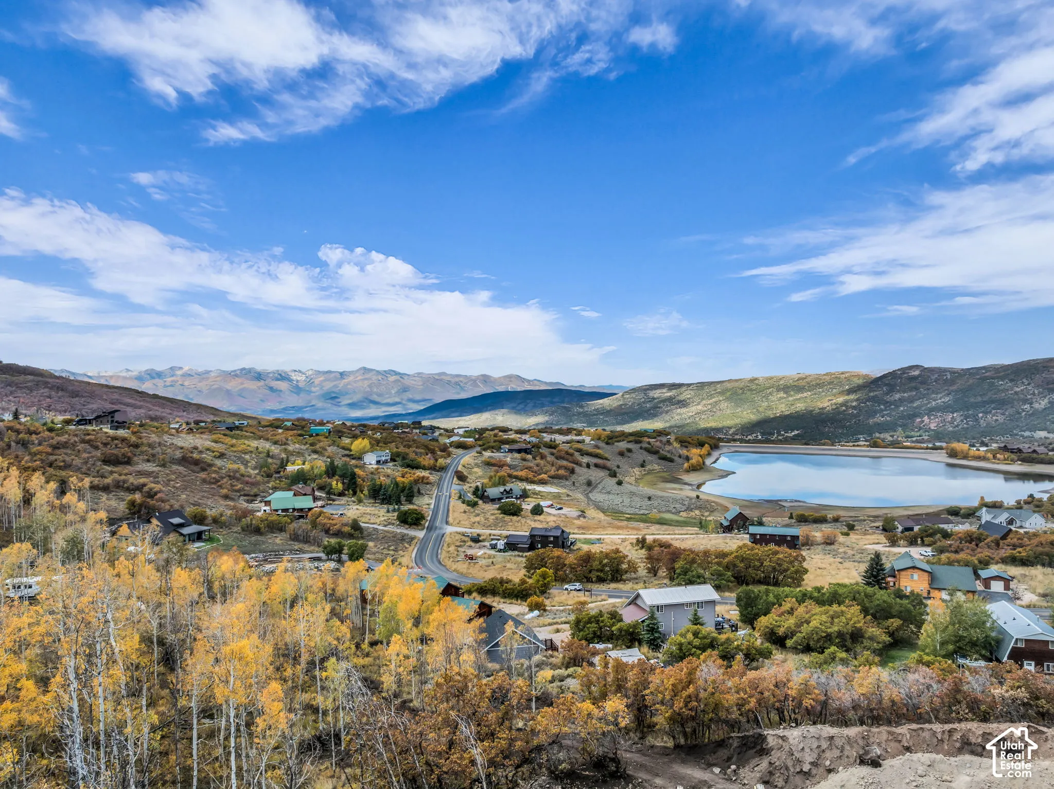 Expansive landscape featuring a prominent lake, distant mountains, and varied terrain