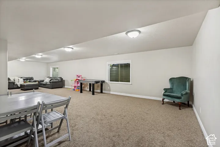 Expansive carpeted room featuring neutral wall tones, recessed lighting, and multiple windows