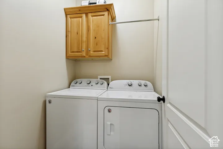 Laundry space featuring built-in wood cabinetry and a metal garment hanging rod