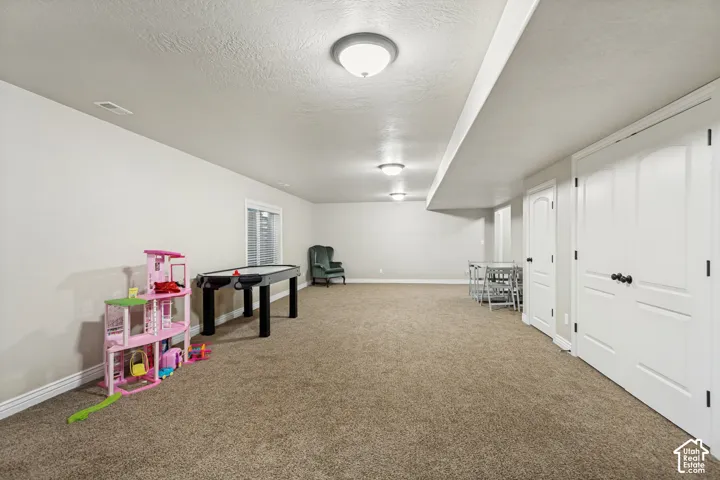 Neutral-toned interior space featuring wall-to-wall carpeting, recessed ceiling lighting, and double-door closet cabinetry with matte black hardware