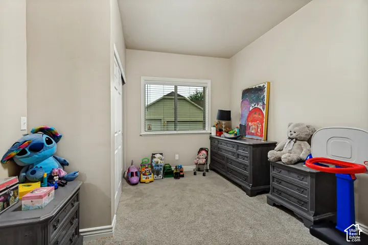 Neutral-toned interior space featuring wall-to-wall carpeting and a dual-pane sliding window