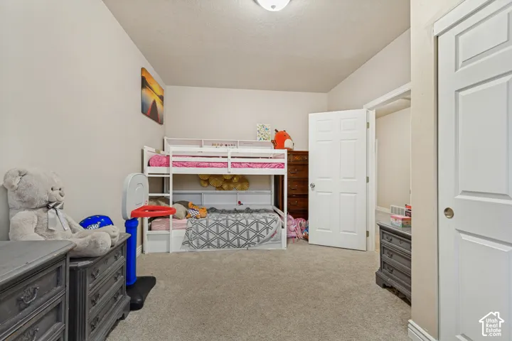 Bedroom featuring neutral wall paint, wall-to-wall carpeting, flush-mount ceiling lighting, and a white six-panel interior door