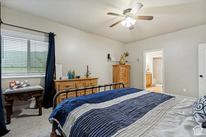 Neutral-toned walls, ceiling fan with integrated lighting, window with horizontal blinds, and wall-mounted shelving